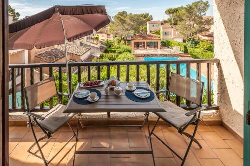 une table et deux chaises sur un balcon dans l'établissement Geschmackvoll eingerichtetes Apartment Le Poisson bleu, 2 Terrassen, Pool, Meerblick, eigener Parkplatz, à Saint-Raphaël