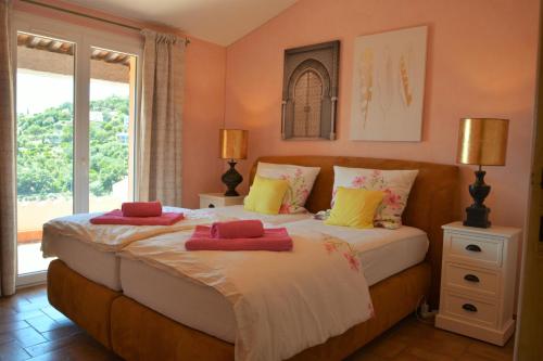 une chambre avec deux lits avec des serviettes dessus dans l'établissement Provenzalisches Haus La Grenouille - Terrasse mit Meerblick und privatem Pool by Riviera HomeLife, aux Issambres