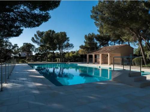 une piscine avec des arbres et un bâtiment dans l'établissement Ferienhaus La Belle Vie mit Garten, Meerblick, Gemeinschaftspool, 3 Minuten zum Meer, à Agay