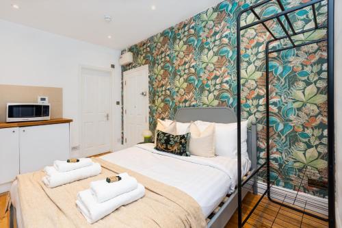 een slaapkamer met een bed met twee handdoeken erop bij DevB1 - Charming Central Studio in Paddington in Londen