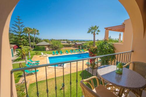 a balcony with a view of the pool and the ocean at Apartamentos Monte dos Avós, Albufeira by AlgarveBlossom in Albufeira