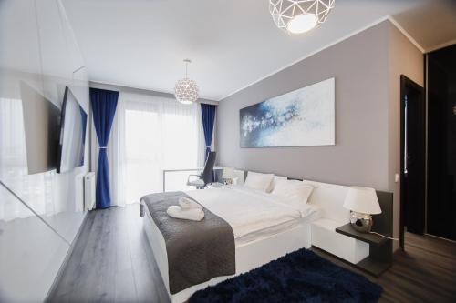 a bedroom with a large white bed and a large window at Luxury Home Affair in Oradea
