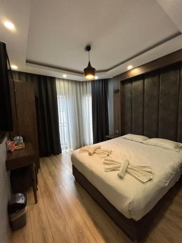 Schlafzimmer mit einem großen Bett mit einem Kopfteil aus Holz in der Unterkunft Basilissis Hotel in Istanbul