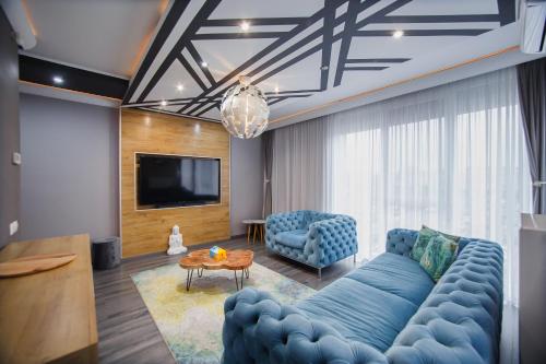 a living room with a blue couch and a tv at Luxury Home Affair in Oradea