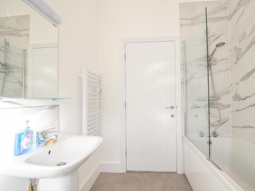 a white bathroom with a sink and a shower at Apartment 5 Victoria House in Lyme Regis