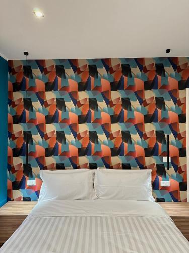 um quarto com uma cama e uma parede colorida em Elegante dimora con biliardino x5 persone, Salerno em Battipaglia