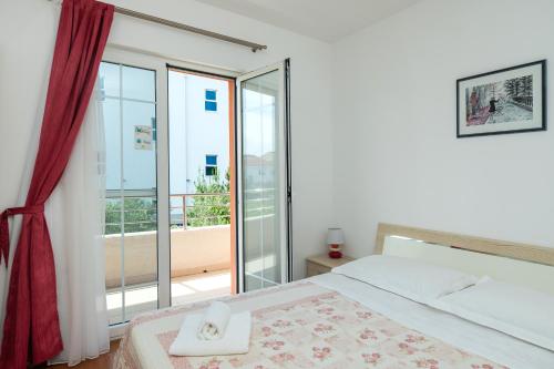 a bedroom with a bed and a large window at Apartment Mario in Vodice