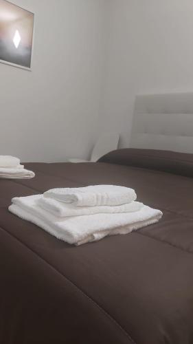 a stack of white towels sitting on a bed at B&B Anastasia in Buccino
