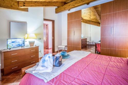 a bedroom with a pink bed and wooden cabinets at Amore Rentals - Maison Palazzo Correale in Sorrento