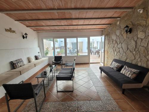a living room with a couch and a stone wall at La Llar de Laura in Poblenou del Delta