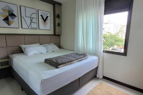 Ce lit se trouve dans un dortoir doté d'une fenêtre. dans l'établissement Lindo apartamento, a 300 m da Praia dos Ingleses!, à Florianópolis