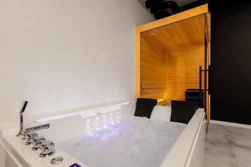a bathroom with a tub with two chairs and a sink at Warowna 2 Premium Spa Jacuzzi & Sauna in Pszczyna