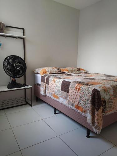 a bedroom with a bed and a lamp on a tiled floor at KitNet Confort Garanhuns (101) in Garanhuns