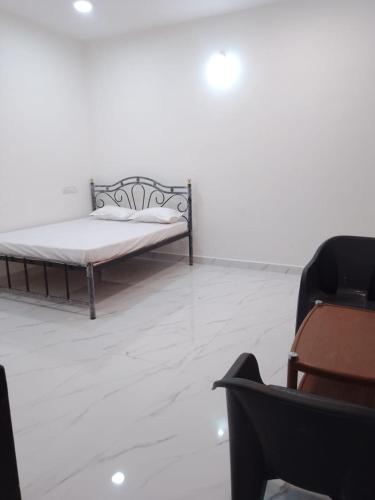 Cette chambre blanche comprend un lit et une chaise. dans l'établissement Wintersky Guest House, à Mandrem