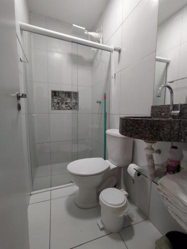 a white bathroom with a shower and a toilet at KitNet Confort Garanhuns (101) in Garanhuns