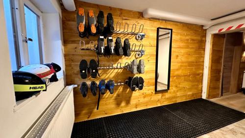 een kamer met een muur met schoenen aan de muur bij Alpen Lodge Riezlern in Riezlern