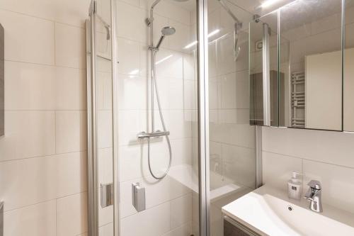 a white bathroom with a shower and a sink at Ferienwohnung Bibi Bocksberg Hahnenklee in Goslar