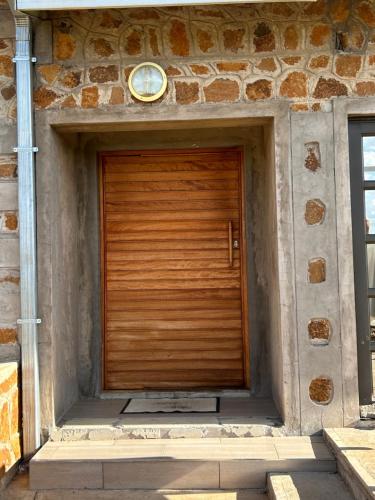 a wooden door on a stone building at Cozy Farm 3BDRM 8 km ThabaBosiu in Maseru