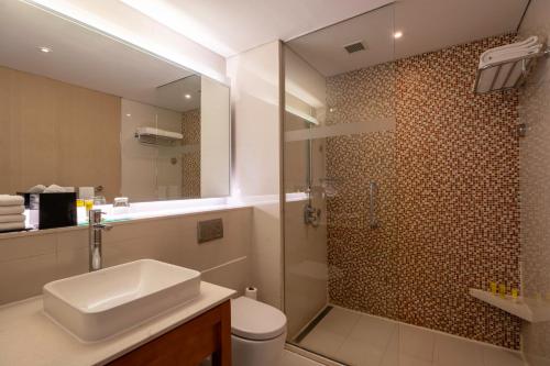 uma casa de banho com um WC, um lavatório e um chuveiro em Hyatt Place Gurgaon Udyog Vihar em Gurgaon