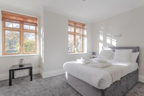 a white bedroom with a large bed and windows at Stunning 5BR 4BA Mansion - Hendon in Hendon