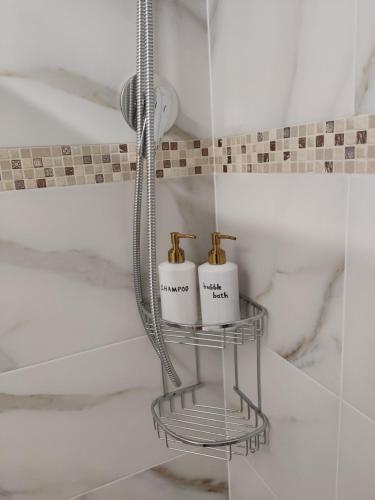 two mugs on a metal shelf in a bathroom at Κοντα στην Ακροπολη in Athens