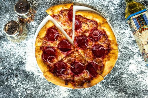a pepperoni pizza sitting on top of a table at Hyatt Place Gurgaon Udyog Vihar in Gurgaon