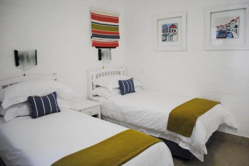 two beds in a room with white walls at 358 Kaliva - Club Mykonos in Langebaan