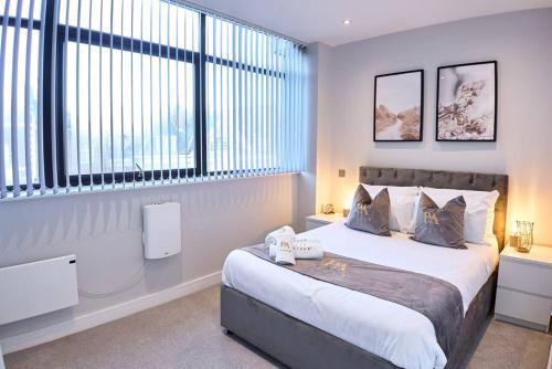 a bedroom with a bed and a large window at Pluxa Arctic - College Road Retreat with Full Apt Full Access in Harrow on the Hill