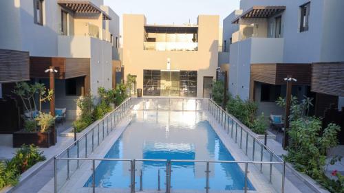 a swimming pool in the middle of a building at No 4 Luxury Villa Compound Al Nada 4 King BedRooms, 5 BathRooms, Two Living Rooms w Smart TVs, 6 Seater Dinning Table, General Swimming Pool, Gym, 4 Seater Outdoor Dinning Table in Riyadh