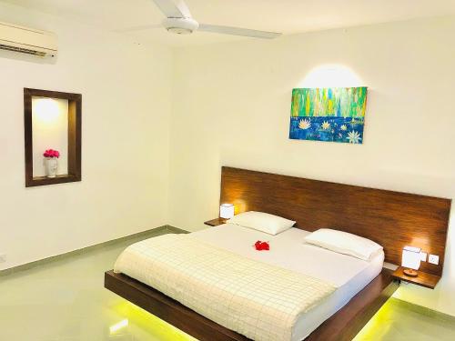 - une chambre avec un lit et une peinture murale dans l'établissement Paradise Garden Beruwala, à Beruwala