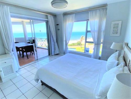 a bedroom with a bed and a view of the ocean at Tahiti 15 in Umdloti