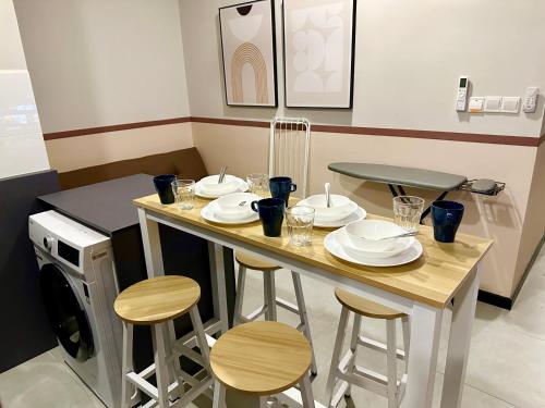 - une table avec des chaises et des assiettes dans la cuisine dans l'établissement Neu Suites, à Kuala Lumpur
