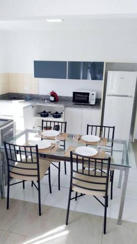 een keuken met een glazen tafel en 4 stoelen bij Apartamento Juvevê. in Curitiba
