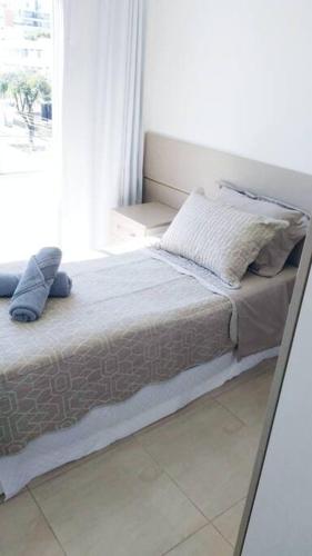 a large bed in a room with a window at Apartamento Juvevê. in Curitiba