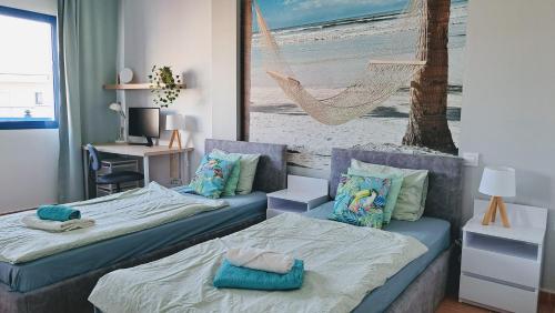 1 Schlafzimmer mit 2 Betten und einem Bild vom Strand in der Unterkunft Widok na basen, Home-Office, Wi-Fi Gratis in Costa Calma