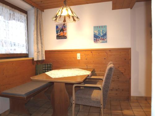 una sala da pranzo con tavolo e sedie in legno di Doppelzimmer oder Appartement ohne Verpflegung a Ellmau