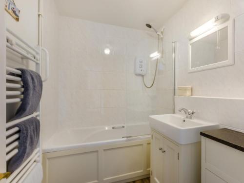 a white bathroom with a sink and a bath tub at 2 Bed in Barnstaple OLDMA in Landkey
