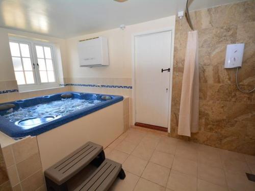 a bathroom with a blue tub and a shower at 3 Bed in Sidmouth HARRI in Talaton