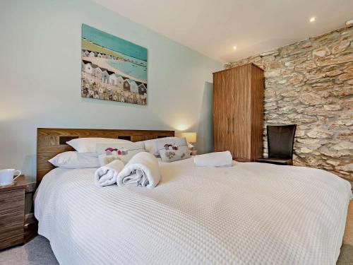 a bedroom with a large white bed with towels on it at 2 Bed in Perranporth WHHOU in Perranporth