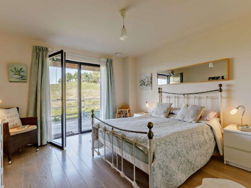 Greintonにある4 bed in Glastonbury SHALOのベッドルーム1室(ベッド1台付)、スライド式ガラスドアが備わります。