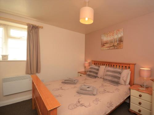 a bedroom with a bed with a wooden headboard and a window at 1 Bed in Burnham-on-Sea ALHSL in Highbridge