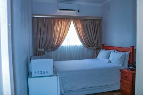 a small bedroom with a bed with a window at Mesda Bed & Breakfast in Empangeni