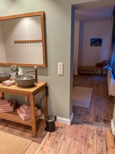 a bathroom with a sink and a mirror on a table at Vakantiehuis Maison Madeleine centrum Ieper in Ypres