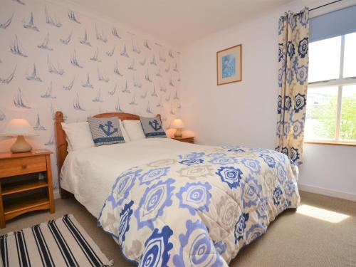 Un dormitorio con una cama azul y blanca y una ventana en 1 Bed in Cardigan MOOST, en Saint Dogmaels