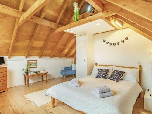 a bedroom with a large bed and wooden ceilings at 2 Bed in Bury St Edmunds OXBAR in Market Weston