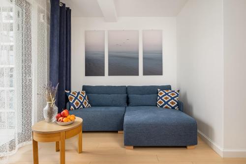 salon z niebieską kanapą i stołem w obiekcie Balticus - Piękny Apartament 200 metrów od PLAŻY Międzyzdroje by Renters w mieście Międzyzdroje