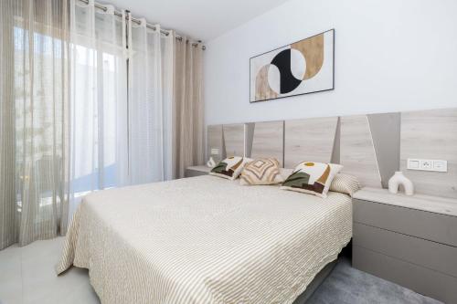 a white bedroom with a bed and a window at Espanatour VALERIA in Torrevieja