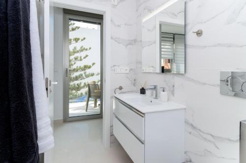 a white bathroom with a sink and a mirror at Espanatour VALERIA in Torrevieja