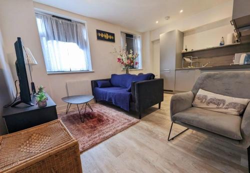a living room with a blue couch and a table at Free Parking Luxury 1 Bed,BHX,NEC,RESORTS WORLD. in Birmingham