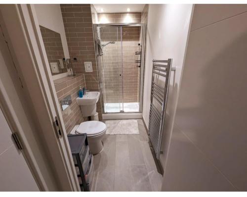 a small bathroom with a toilet and a shower at Free Parking Luxury 1 Bed,BHX,NEC,RESORTS WORLD. in Birmingham